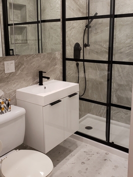 Salle de bain moderne avec douche vitrée, un lavabo et un toilette