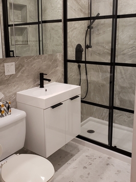 Modern bathroom with glass-enclosed shower, sink and toilet