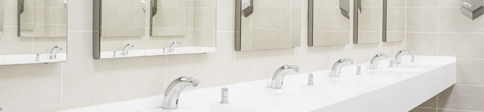 Large row of sinks with mirror and wall-mounted hand dryer