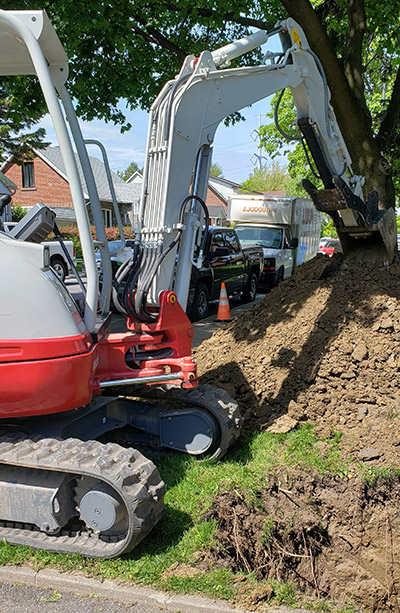 Backhoe that deposits soil on a pile