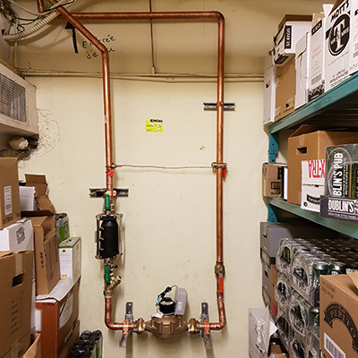 Water meter in a storage room with cartons and drinks